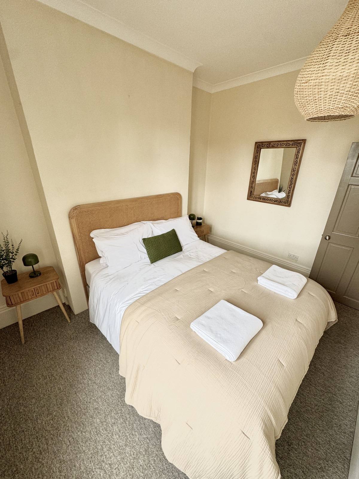 Double bedroom with bedside table, mirror and soft natural light